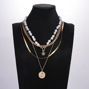 Gold-toned four-layered necklace set featuring pearls and a textured Yin Yang pendant
