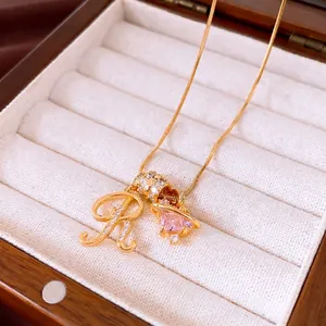 Elegant 18k gold plated necklace featuring zircon encrusted letter R and pink planet charms