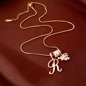 Detailweergave van de 18k vergulde ketting met R-initiaal en hartplaneet-hangers