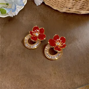 Detailopname van rode emaille bloemenoorbellen met ronde zirkonia halo glans