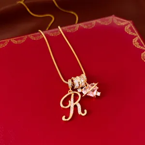 Detailweergave van een 18k vergulde ketting met zirkonia letter R en roze hartje
