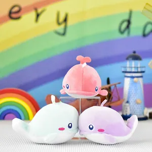 Three colorful cute plush whale keychains shown together on a desk with rainbow backdrop