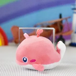 Detail view of a cute pink whale plush toy pendant with embroidered features