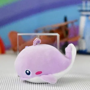 Close-up of a cute purple plush whale keychain pendant with soft fabric details.