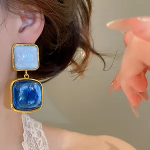 Detailansicht von vintage sternenblauen quadratischen Anhänger-Ohrringen an einem Modell