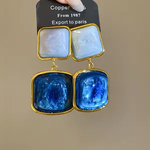 Detailansicht von vintage blauen Sternenhimmel-Ohrringen mit goldenen Metallrahmen