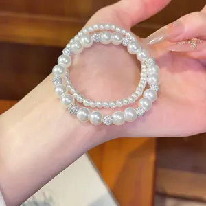 Nahaufnahme eines eleganten zweireihigen Perlenarmbands mit glänzenden Strass-Kugeln