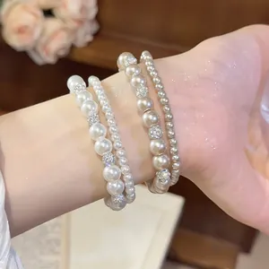 Detailansicht eines eleganten 4-teiligen Perlenarmband-Sets mit funkelnden Lehm-Diamantkugeln
