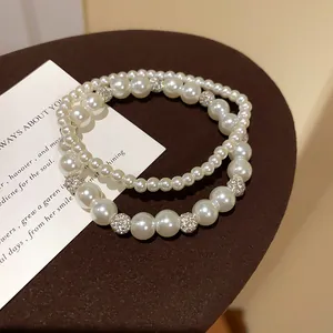 Nahaufnahme eines doppellagigen Perlenarmband-Sets mit funkelnden Kristallkugeln