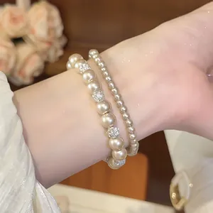 Detailaufnahme eines eleganten Perlenarmband-Sets im französischen Stil mit Glitzerkugeln