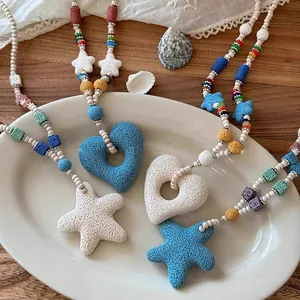 Detail view of volcanic stone heart and starfish pendants on a colorful beaded necklace