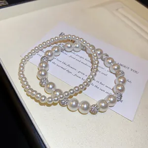 Detailaufnahme eines eleganten Perlenarmband-Sets mit funkelnden Strass-Tonkugeln.