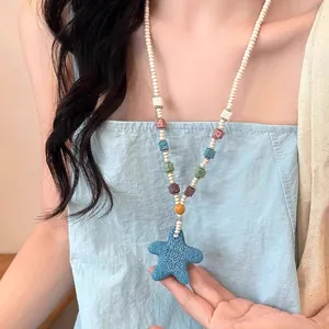 Macro detail of dopamine style colorful beaded necklace with blue volcanic stone starfish