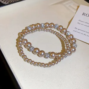 Detail eines eleganten französischen Perlenarmband-Sets mit funkelnden Strasskugeln