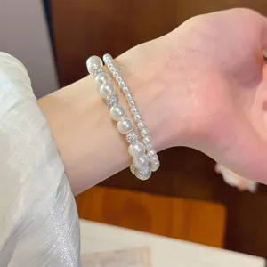 Nahaufnahme eines eleganten zweilagigen Perlenarmband-Sets mit glänzenden Schmuckperlen