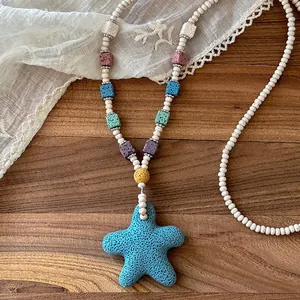 Macro view of a colorful beaded necklace featuring a textured blue lava stone starfish pendant