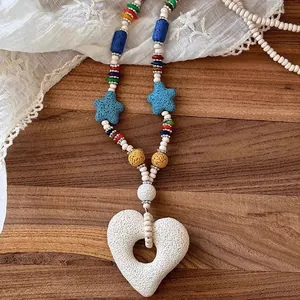 Close-up of the heart-shaped volcanic stone pendant on a colorful beaded necklace