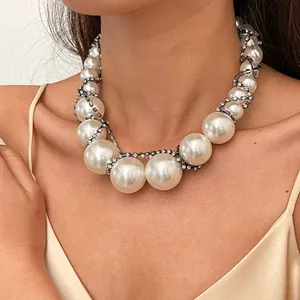 Detailaufnahme einer klobigen Vintage-Perlenkette mit Strass-Akzenten an einem Modelhals