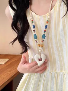 Detailed view of the colorful beaded volcanic stone necklace featuring a large heart pendant