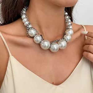 Detailansicht einer vintage klobigen Perlenkette mit Strassbesatz am Hals des Modells