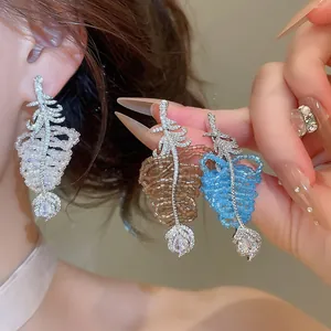 Gros plan de boucles d'oreilles étincelantes en zircone en blanc, marron et bleu