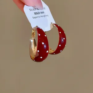 Vue détaillée des créoles vintage en émail rouge à pois blancs avec étiquette S925.