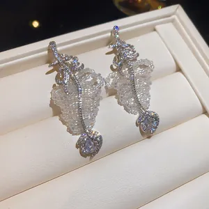 Gros plan détaillé de boucles d'oreilles pendantes feuille en zircon avec perles blanches fines