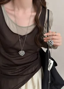Gros plan d'un collier de luxe français en forme de cœur avec strass sur un mannequin.