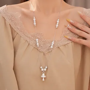 Detailansicht einer eleganten Perlen- und Silberperlenkette mit süßem Pilzanhänger