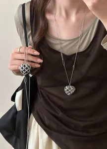 Détail d'un collier avec pendentif en forme de cœur en acrylique de style français sur un mannequin