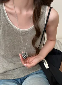 Vue détaillée d'un collier avec pendentif cœur en acrylique et strass sur un mannequin