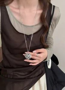Vue détaillée d'un collier cœur de luxe français avec des strass étincelants sur un modèle.
