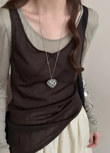 Détail d'un collier avec pendentif cœur en acrylique et strass sur un mannequin