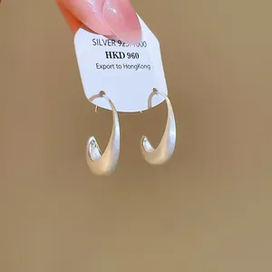 Detailed macro view of minimalist brushed metal hoop earrings in S925 silver finish
