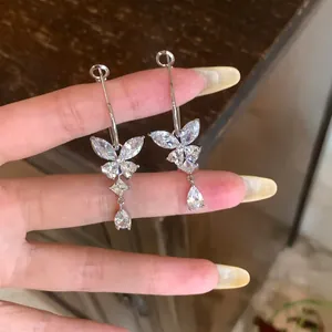 Detailopname van elegante zilveren vlinder oorbellen met fonkelende zirkonia's