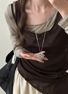 Détail de collier pendentif cœur en acrylique avec strass sur une longue chaîne argent