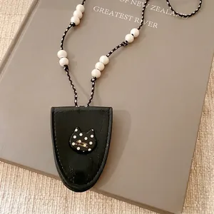 Collar informal con colgante de cuero negro, dije de gato con lunares y cuentas blancas