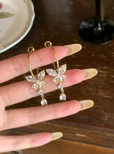 Detailopname van elegante gouden vlinder oorbellen met fonkelende zirkonia kwastjes