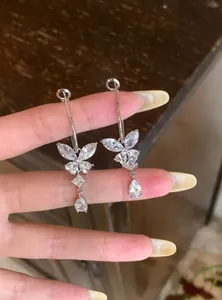 Close-up van elegante zilveren vlinderoorbellen met schitterende zirkonia kwastjes