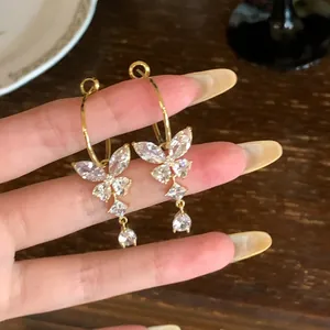Gedetailleerde weergave van gouden vlinder oorbellen met fonkelende zirkonia stenen detail