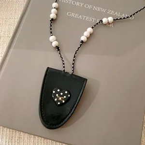 Detailansicht der Lederhalskette mit Herz-Polka-Dot-Anhänger und weißen Perlen