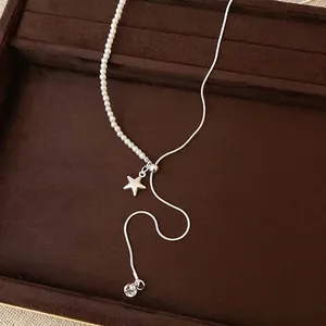 Elegante collana asimmetrica con perle e catena d'argento su vassoio di velluto