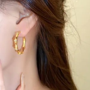 Close-up of elegant gold bamboo knot earrings with sparkling crystal accents