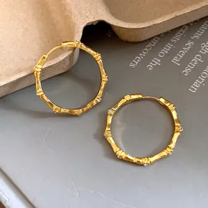 Close-up look at the textured gold bamboo hoop earrings with diamond-like stones
