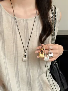Detailoverzicht van vintage metalen ketting met ronde hanger in goud en zilver