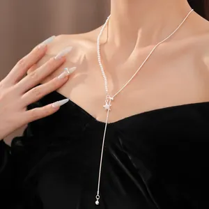 Detailaufnahme einer asymmetrischen Halskette mit Perlen und Sternanhänger am Model