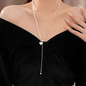 Elegante Nahaufnahme einer asymmetrischen Herzanhänger-Halskette mit Perlen und Silberkette