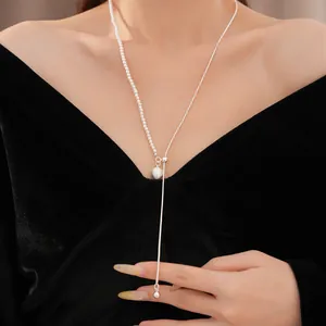 Detailaufnahme einer asymmetrischen Halskette mit Perlen und gebürsteter Metallperle