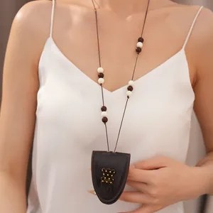Detail der braunen Brillenclip-Halskette aus Leder mit Perlen und Bärenanhänger.
