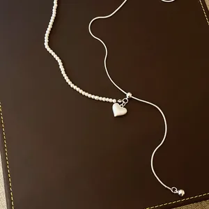 Detailansicht der asymmetrischen Perlenkette mit gebürstetem Herzanhänger in Silber